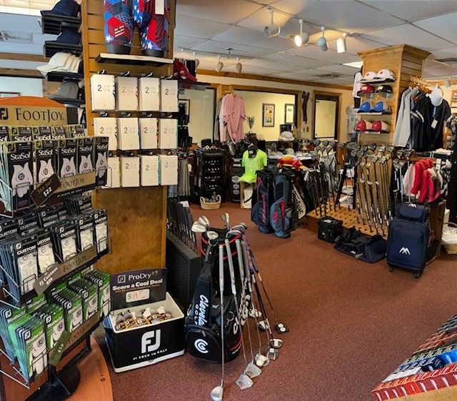 A store with golf clubs and bags on the floor.